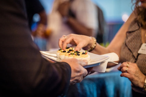 person picking up a caviar appetizer from a server's tray