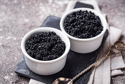 Sturgeon caviar in two white bowls