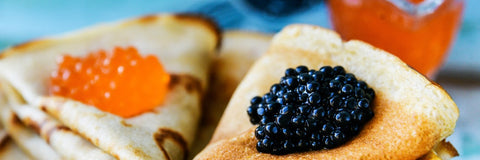 orange and black caviar on top of folded blinis