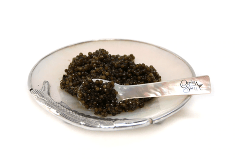 caviar in a pearl bowl being scooped with a pearl spoon